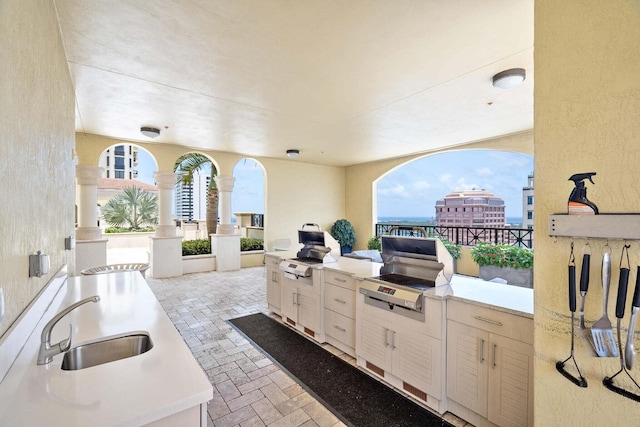 view of patio featuring area for grilling, sink, and a grill