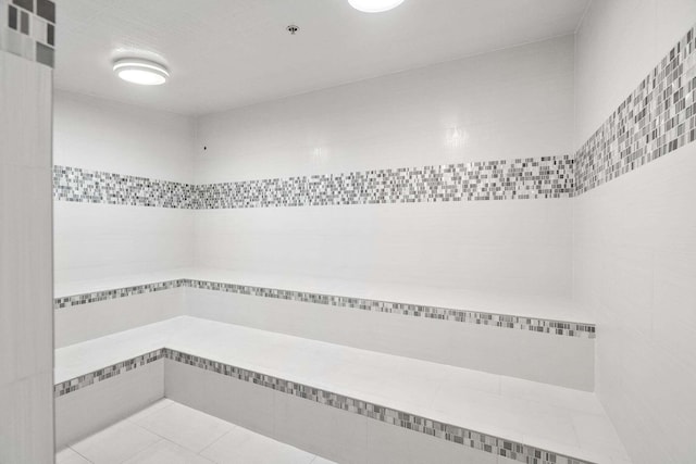 full bath featuring visible vents, a tile shower, and tile patterned floors