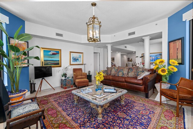 tiled living room with an inviting chandelier and decorative columns