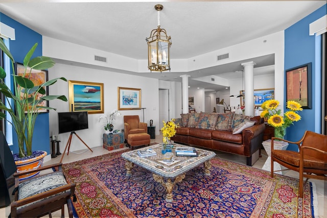 living room featuring ornate columns, visible vents, and tile patterned floors