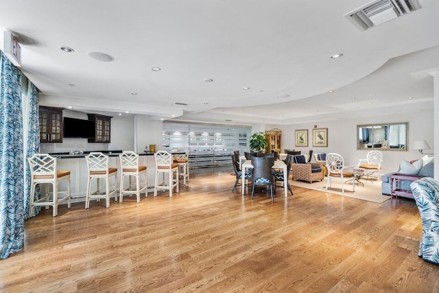 dining area featuring light hardwood / wood-style floors and a raised ceiling