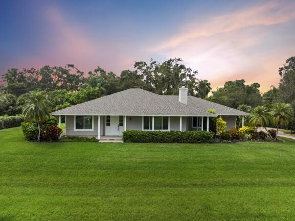 ranch-style home featuring a lawn