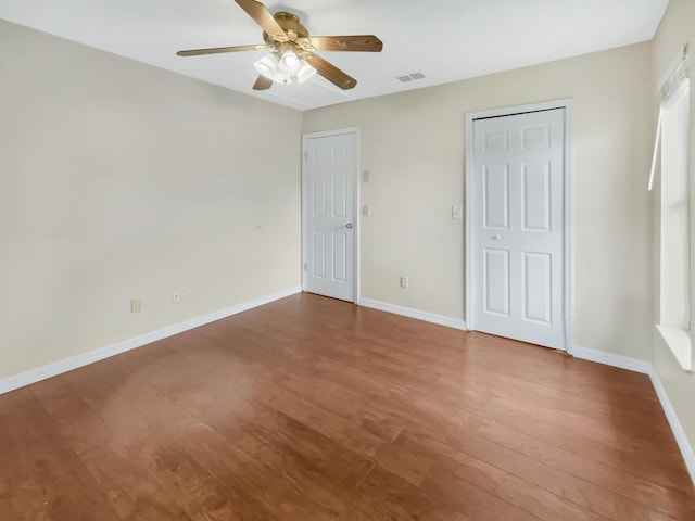 unfurnished bedroom with a closet, hardwood / wood-style flooring, and ceiling fan