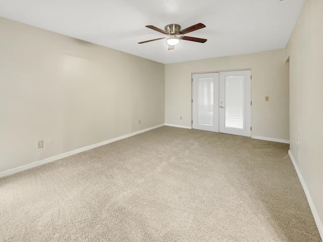 carpeted spare room with french doors and ceiling fan