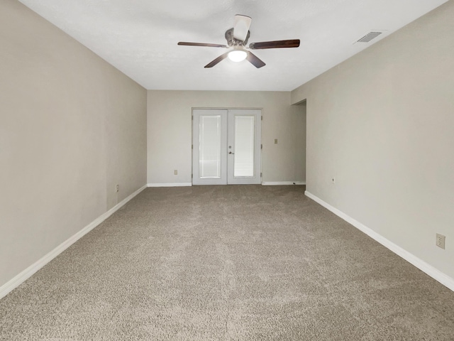 spare room featuring french doors, carpet flooring, and ceiling fan