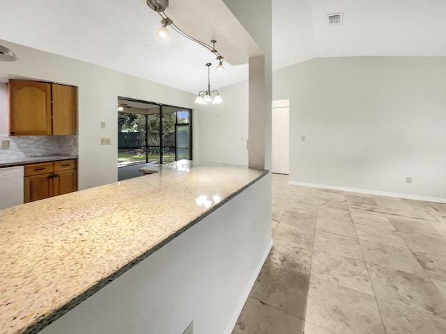 kitchen with vaulted ceiling, backsplash, dishwasher, decorative light fixtures, and light stone countertops