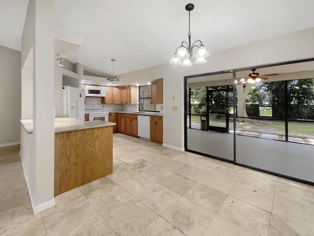 kitchen with white appliances, hanging light fixtures, vaulted ceiling, and kitchen peninsula