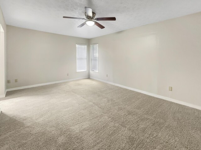 spare room with ceiling fan and carpet