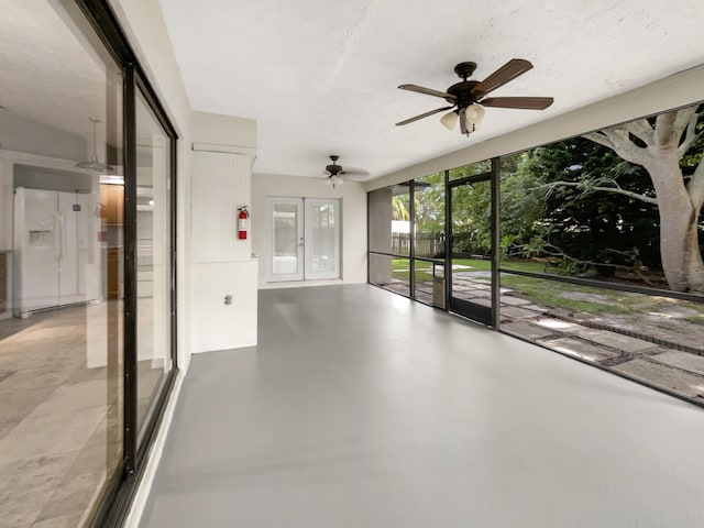 unfurnished sunroom featuring ceiling fan