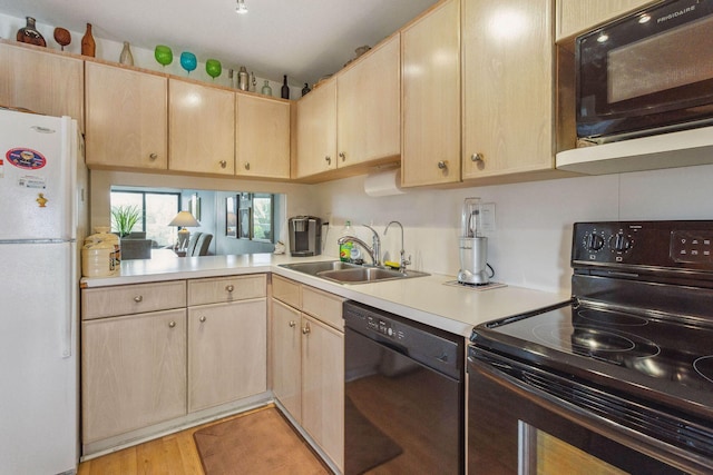 kitchen featuring sink, light brown cabinetry, black appliances, and light wood-type flooring