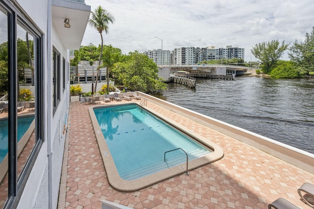 view of pool with a patio and a water view