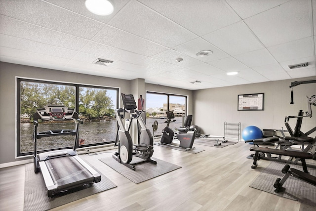 workout area with hardwood / wood-style floors and a drop ceiling