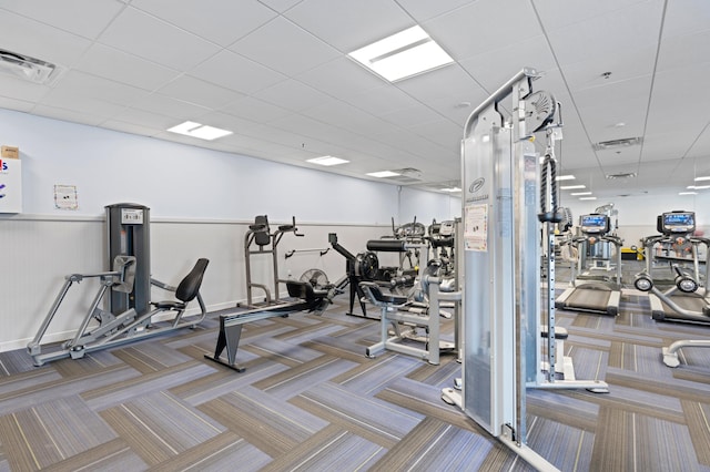 exercise room with carpet floors and a paneled ceiling