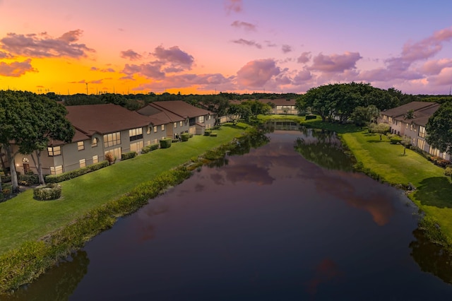 aerial view at dusk featuring a water view