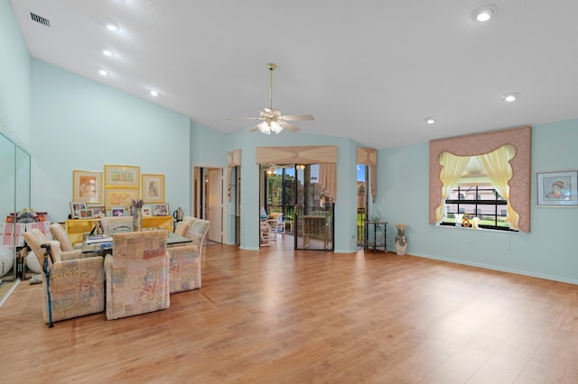 living room featuring ceiling fan, high vaulted ceiling, and light hardwood / wood-style floors