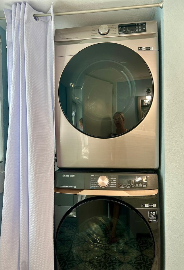 clothes washing area featuring stacked washer and dryer