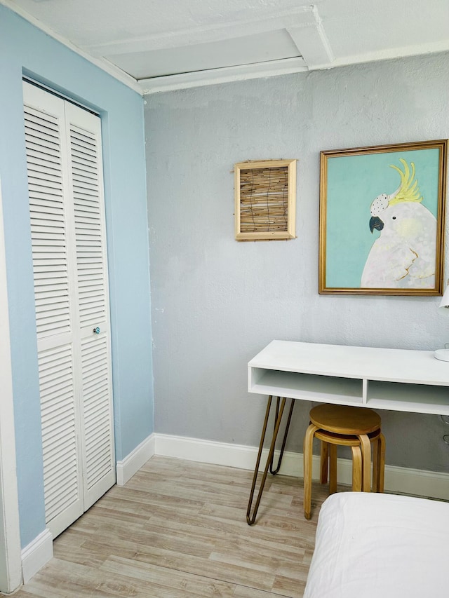 bedroom with light hardwood / wood-style flooring and a closet