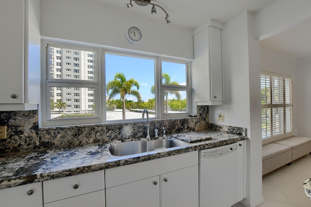 kitchen with plenty of natural light, backsplash, dishwasher, and light tile patterned floors