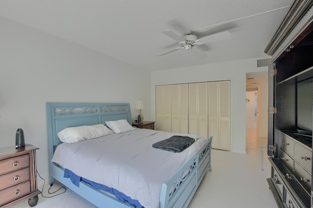 bedroom featuring ceiling fan, a closet, and light tile patterned floors