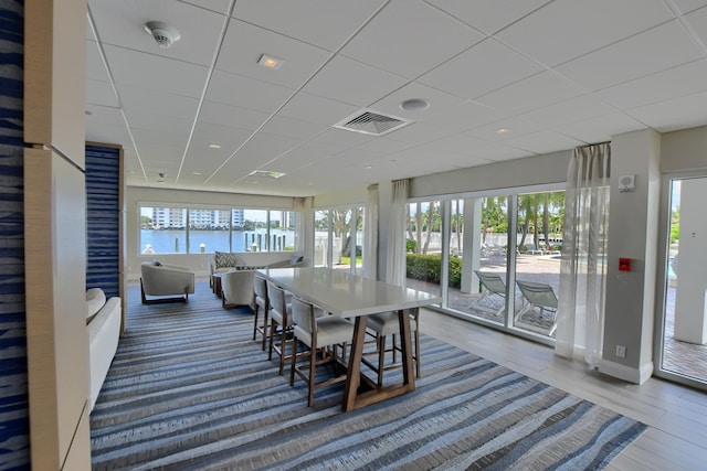 dining space featuring a healthy amount of sunlight and a paneled ceiling