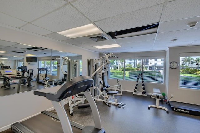 exercise room with a wealth of natural light and a drop ceiling