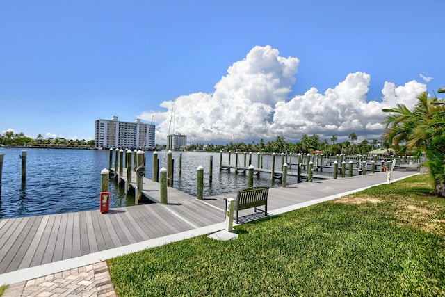 view of dock featuring a lawn and a water view