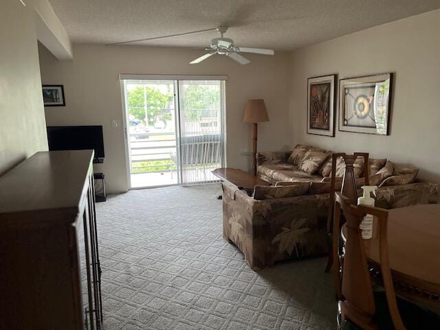 carpeted living room with ceiling fan and a textured ceiling