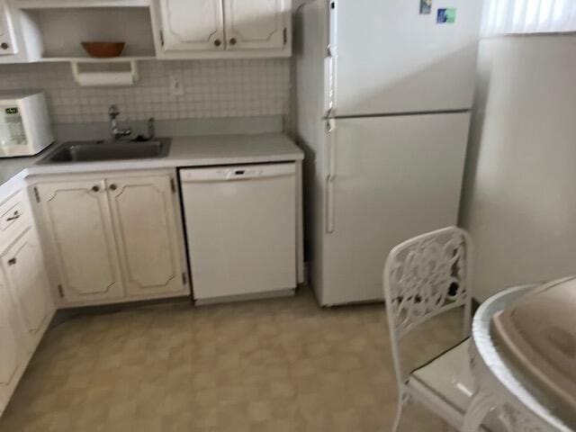 kitchen with white cabinets, white appliances, tasteful backsplash, and sink