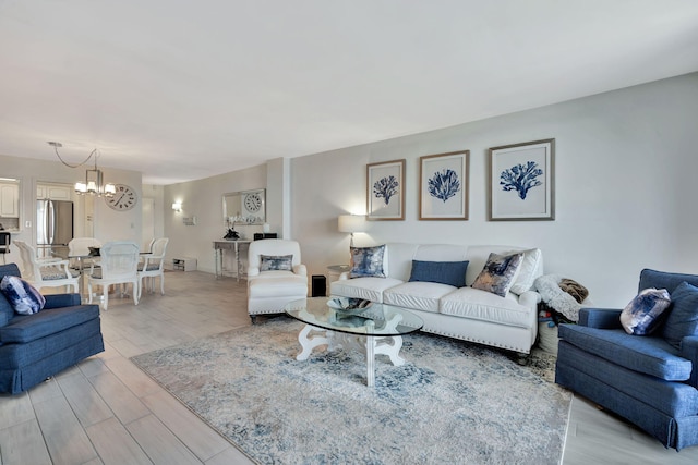 living room with light wood-type flooring and an inviting chandelier