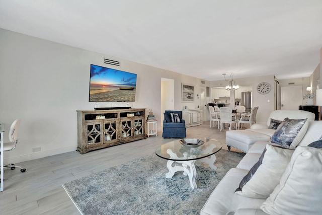 living room featuring a chandelier and light hardwood / wood-style floors