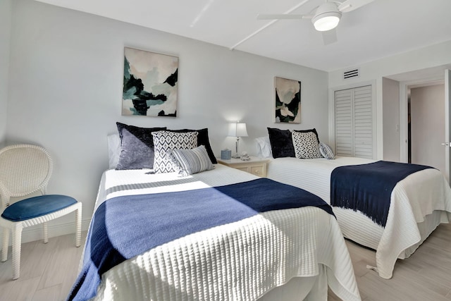 bedroom featuring ceiling fan, light wood-type flooring, and a closet