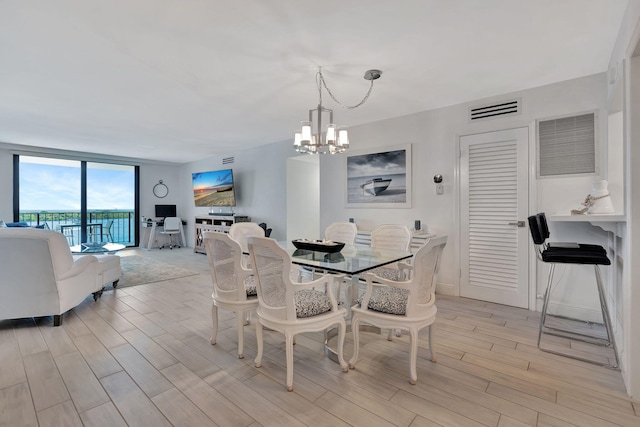 dining area featuring an inviting chandelier and floor to ceiling windows