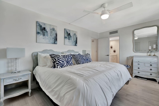 bedroom with connected bathroom, ceiling fan, and light hardwood / wood-style flooring