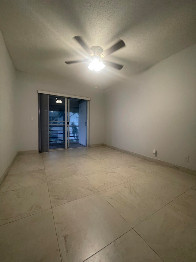 interior space with ceiling fan, light tile patterned floors, and a textured ceiling