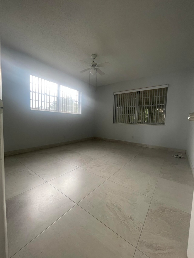 empty room featuring ceiling fan and light tile patterned flooring