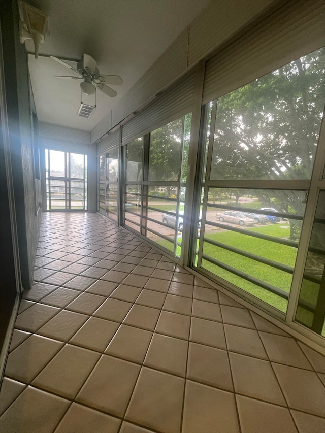 unfurnished sunroom with ceiling fan