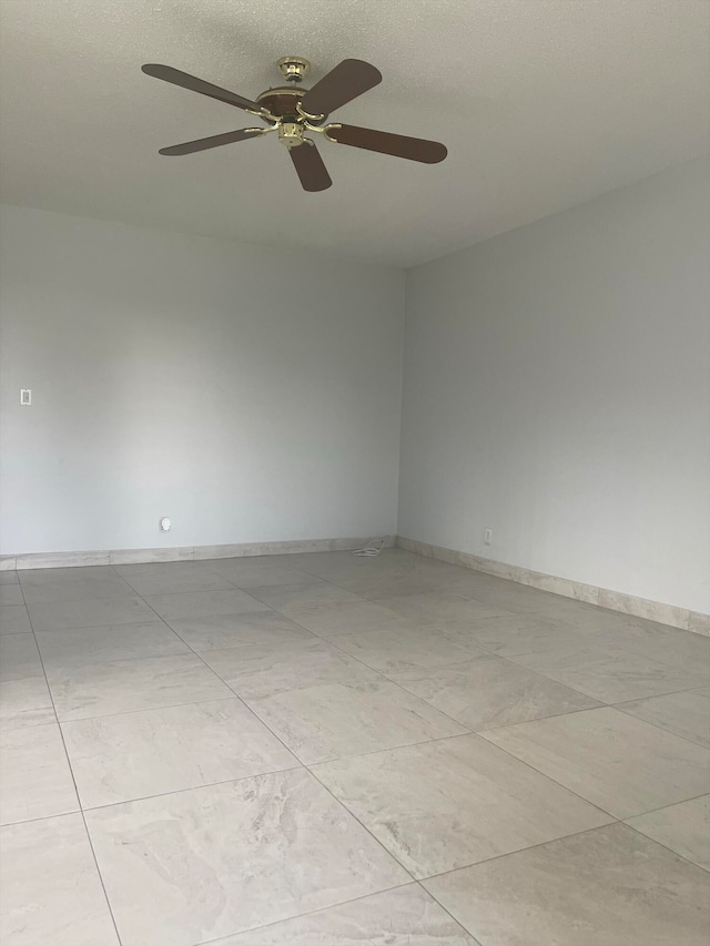 empty room featuring ceiling fan and light tile patterned floors