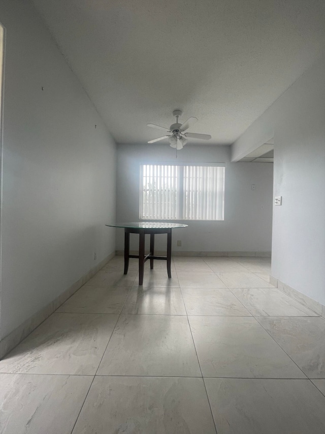 empty room featuring ceiling fan and light tile patterned floors