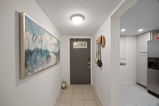 doorway featuring a textured ceiling and light tile patterned floors