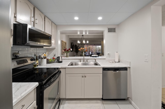 kitchen with sink, decorative backsplash, appliances with stainless steel finishes, and light tile patterned floors