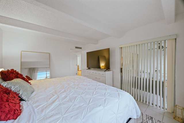 bedroom featuring beamed ceiling and light tile patterned floors