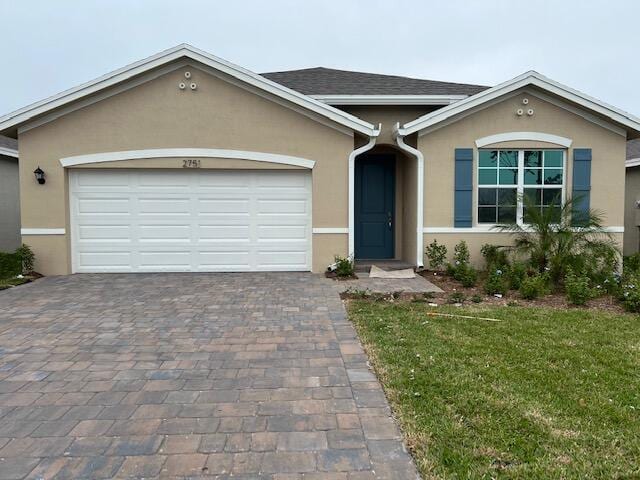 ranch-style home featuring a garage and a front lawn