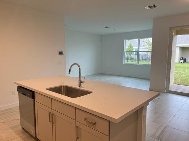 kitchen featuring sink, plenty of natural light, an island with sink, and dishwasher