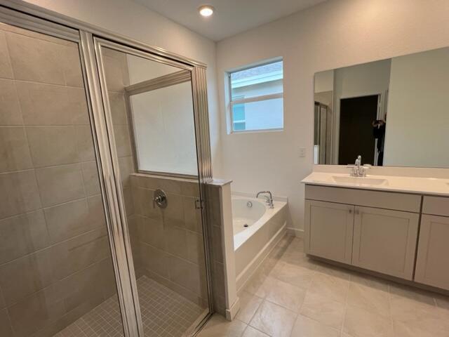 bathroom featuring shower with separate bathtub, tile patterned floors, and vanity