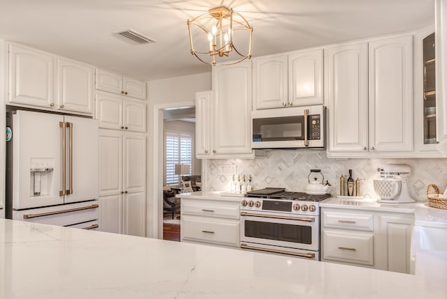 kitchen featuring white cabinets, premium appliances, and tasteful backsplash