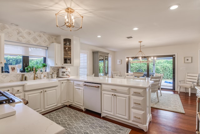 kitchen with dishwasher, white cabinets, and hanging light fixtures