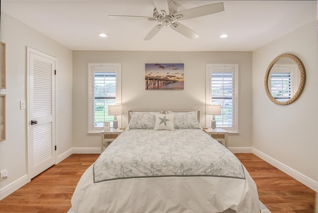 bedroom with hardwood / wood-style floors, multiple windows, and ceiling fan