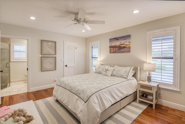 bedroom featuring multiple windows, a closet, light hardwood / wood-style floors, and ceiling fan