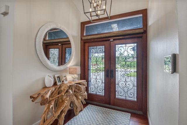 foyer entrance featuring french doors, a notable chandelier, and wood-type flooring