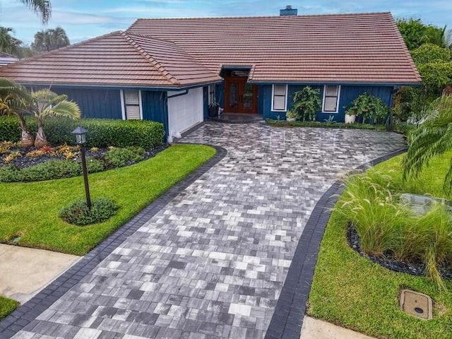 ranch-style home featuring a front yard and a garage